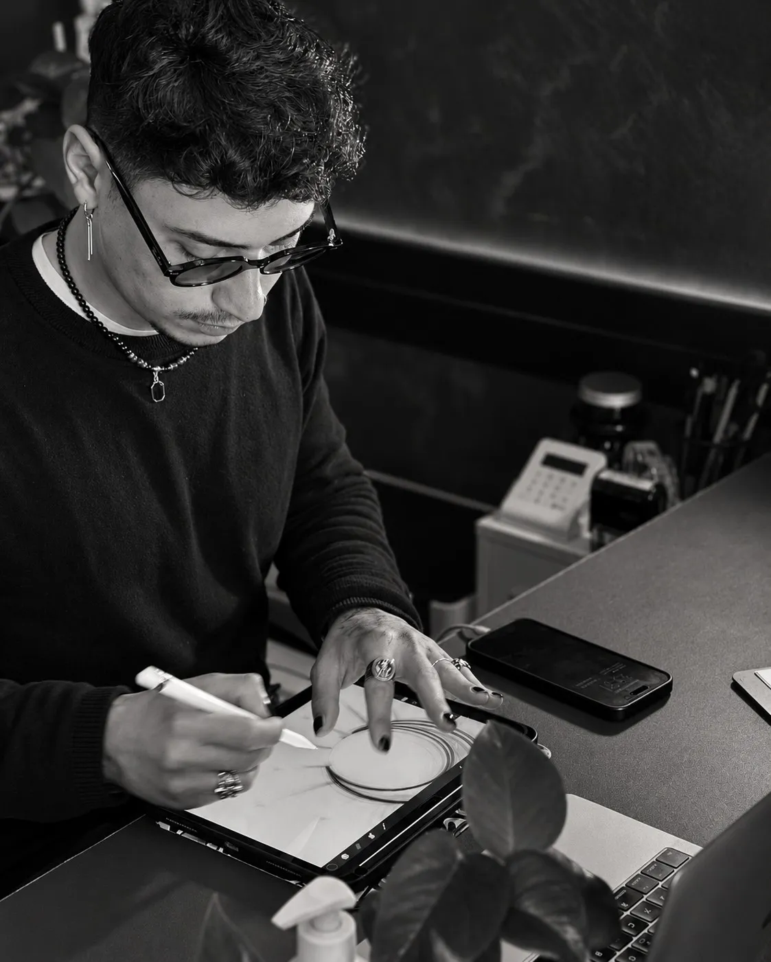 Jhomie al tavolo mentre disegna un tatuaggio sul tablet